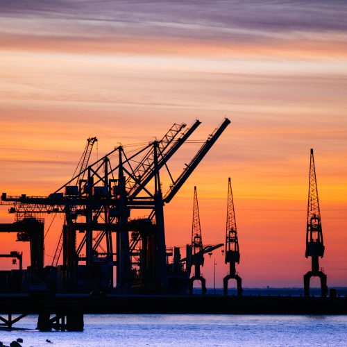 A beautiful silhouette of port machinery during sunset